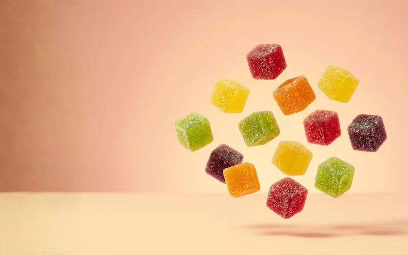 Colorful THC gummies floating on vibrant background